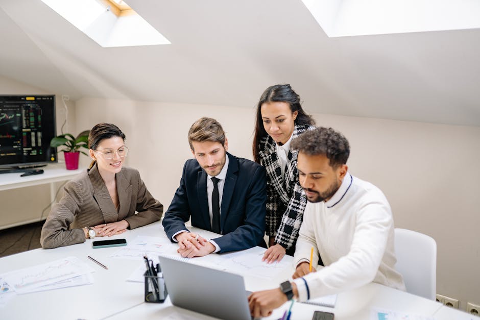 A team in a meeting around laptops in an office
