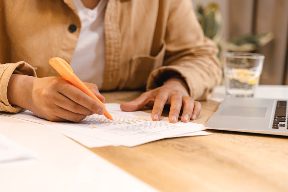A person editing and highlighting text in a document on a laptop