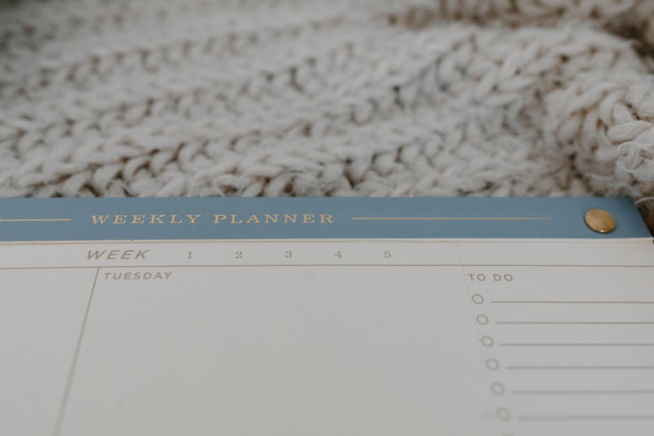 A weekly planner and calendar laid out on an office desk