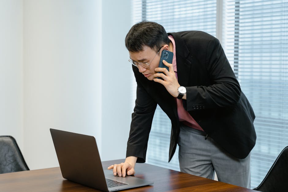 Salesperson on a phone call with a laptop in an office